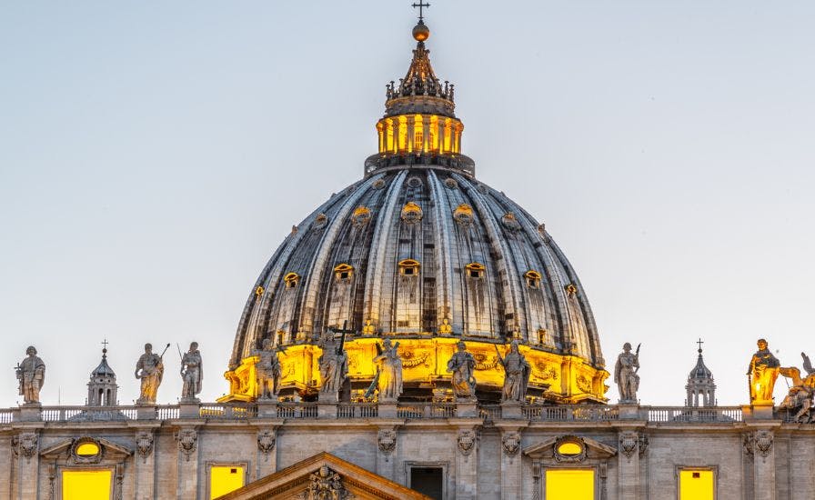 Illuminated Vatican dome at twilight, part of St. Peter’s Basilica Dome Tour.