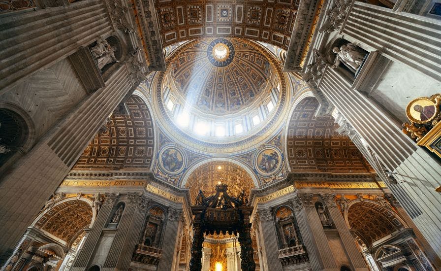 Inside St. Peter's Basilica, a majestic cathedral, showcasing a breathtaking ceiling with a magnificent dome.
