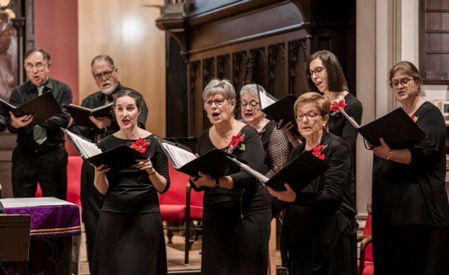 Tourists walking on Piazza del Santuario in Rome, with a view of St. Peter's Basilica in the background.