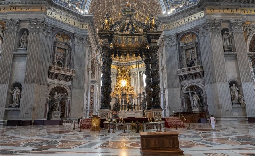 Interior of St Peter Basilica with statues and golden altar